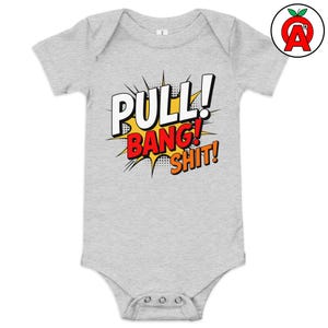May include: A light gray baby onesie with the words "PULL! BANG! SHIT!" in a comic book style. The text is in white, red, and orange, with a yellow burst background. The onesie has a round neck and snap closures.