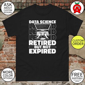 May include: Black t-shirt with a white graphic that reads "DATA SCIENCE LEGEND RETIRED BUT NOT EXPIRED." The design includes a laptop with code on the screen and hands typing on a keyboard. The shirt has a classic fit.