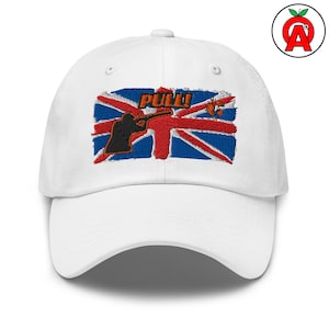 Könnte beinhalten: Weiße Baseballkappe mit Union Jack-Flaggen-Design. Die Flagge zeigt eine schwarze Silhouette einer Person, die ein Gewehr anvisiert, mit dem Wort "PULL!" darüber gestickt. Auf der Seite befindet sich ein rotes Apfel-Logo.