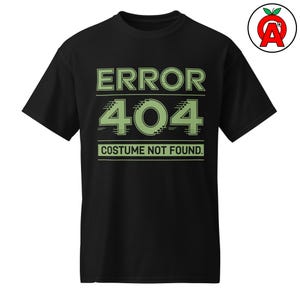 May include: Black t-shirt featuring the text "ERROR 404 COSTUME NOT FOUND" in light green. The text is centered on the front. The shirt has a crew neck and short sleeves.