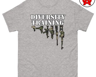 May include: A heather gray t-shirt with the words "DIVERSITY TRAINING" in white block letters. Below the text are several stylized illustrations of firearms in various camouflage patterns.