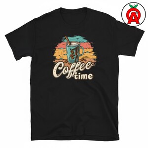 Może przedstawiać: Czarny t-shirt z krótkim rękawem z nadrukiem graficznym przedstawiającym niebieski kubek do kawy z laską cynamonu, otoczony ziarnami kawy. Wzór zawiera tło w kolorach zachodu słońca z poziomymi liniami oraz napis Coffee time w stylu pisma.