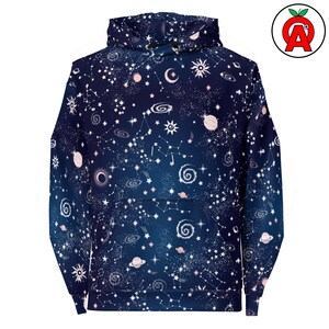 May include: A dark blue hooded sweatshirt featuring an all-over print of white and light pink celestial elements, including stars, planets, galaxies, suns, moons, and constellations. The garment includes a front kangaroo pocket and a hood.