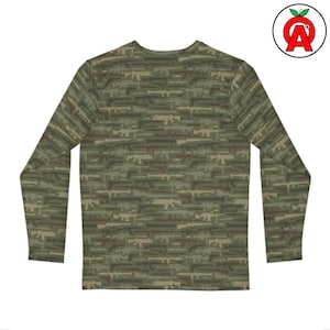 Può includere: Maglia a maniche lunghe con un motivo mimetico composto da fucili in tonalità verdi, marroni e beige. La maglia ha un girocollo e un design aderente, adatta per l'uso quotidiano.