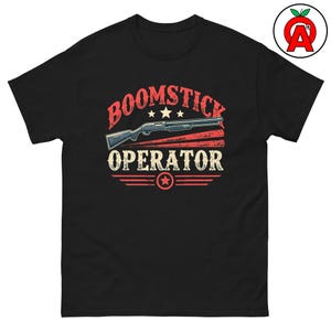 May include: Black t-shirt with a vintage-style graphic of a shotgun and the text "BOOMSTICK OPERATOR" in white and red.