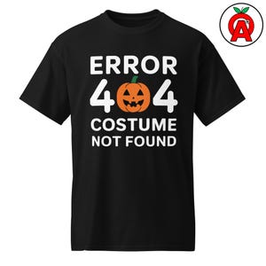 Könnte beinhalten: Schwarzes T-Shirt mit dem weißen Text "ERROR 404 COSTUME NOT FOUND". In der Mitte befindet sich eine Kürbis-Grafik. Das Shirt hat einen Rundhalsausschnitt und kurze Ärmel.