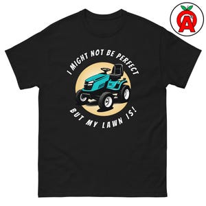 Puede incluir: Camiseta negra con un gráfico de tractor cortacésped turquesa dentro de un círculo amarillo. El texto dice "I MIGHT NOT BE PERFECT BUT MY LAWN IS!" en blanco. La camiseta es de mezcla de algodón pesado.