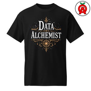 May include: Black t-shirt featuring the text "DATA ALCHEMIST" in white and gold. The design incorporates ornate detailing and a central circular motif. The shirt has a crew neck.