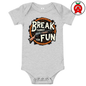 Könnte beinhalten: Hellgrauer Baby-Body mit dem Aufdruck "BREAK THINGS FOR FUN". Das Design zeigt eine Schrotflinten-Illustration in einem schwarzen und orangefarbenen Kreis.
