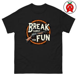 Könnte beinhalten: Schwarzes T-Shirt mit einem Grafikdesign, das eine Schrotflinte und die Worte "BREAK THINGS FOR FUN" in einem Used-Look zeigt. Das Design ist in einem kreisförmigen orange-weißen Muster gehalten.