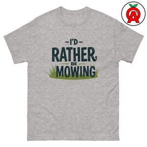 Peut inclure: Un t-shirt gris chiné avec le texte "I'd Rather Be Mowing" en noir avec des accents d'herbe verte.