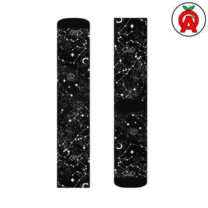 May include: A pair of black socks featuring a white celestial design. The socks display constellations, stars, and crescent moons. The design covers the entire sock, creating a night sky effect. The socks are made of a soft, comfortable material.