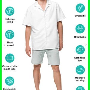Op de afbeelding: Een wit shirt met korte mouwen en een open kraag en lichtgrijze shorts. Het shirt heeft een unisex pasvorm en is lichtgewicht. De afbeelding toont ook pictogrammen voor sneldrogende, ademende en vochtafvoerende eigenschappen.