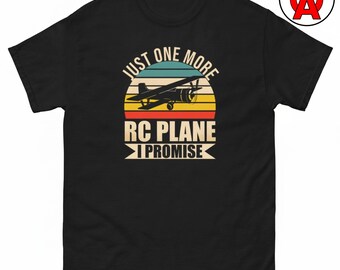 Op de afbeelding: Een zwart t-shirt met korte mouwen en een afbeelding van het silhouet van een vliegtuig in vintage-stijl, gecentreerd over een veelkleurige zonsondergangcirkel. De tekst JUST ONE MORE RC PLANE I PROMISE staat in een vetgedrukt lettertype.