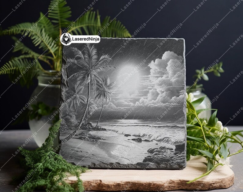May include: A black and white engraved slate coaster featuring a tropical beach scene with palm trees, a cloudy sky, and ocean waves.