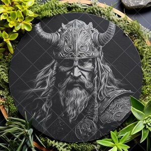 May include: A black and white illustration of a Viking warrior with a horned helmet and a long beard. The illustration is on a round, black slate plaque.