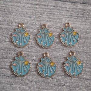 Peut inclure: Six breloques en métal identiques en forme de coquillage, chacune avec un émail bleu clair, une petite étoile jaune, un minuscule cœur rose et des accents circulaires blancs. Chaque breloque possède une petite boucle en métal au sommet.