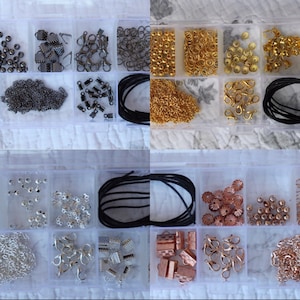 以下が含まれることがあります： さまざまなジュエリー作りのための用品が入った透明なプラスチック製の収納ボックス。ボックスには、金、銀、黒の金属製の留め具、ジャンプリング、ビーズ、チェーンが入っています。黒いコードの糸巻きもあります。