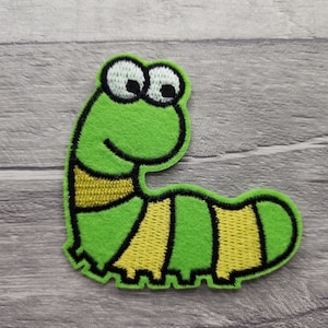 Peut inclure: Chenille verte avec des rayures jaunes et des contours noirs. La chenille a de grands yeux blancs avec des pupilles noires et une bouche souriante.