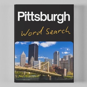 Könnte beinhalten: Ein Buch mit dem Titel Pittsburgh Word Search mit schwarzem Einband, weißem Text und gelber Schreibschrift. Der untere Teil zeigt ein Foto der Skyline von Pittsburgh mit einer gelben Brücke über einem Fluss unter einem blauen Himmel.