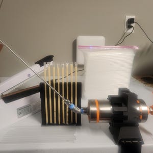 May include: A white heat sealer with a silver metal rod, a black stand with a row of clear plastic tubes, a silver and orange hand-operated pump, and a white bag filled with cotton swabs.