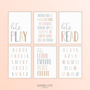 May include: Set of six printable wall art prints with a pastel colour scheme. The prints feature the words "let's play", "let's read", "let's learn, explore, build, create", the alphabet, and numbers 1-20.