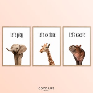 May include: Three framed prints with white backgrounds and black text. The prints feature a baby elephant, a giraffe, and a hippopotamus. The text on the prints reads "Let's play", "Let's explore", and "Let's create".