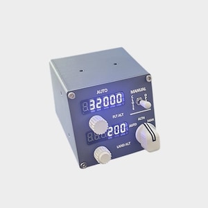 May include: A gray electronic device with digital displays showing numbers. The device has white knobs and a switch labeled "Manual." The top display reads "8.32000" and the bottom reads "8.6200." The word "AUTO" is above the top display.