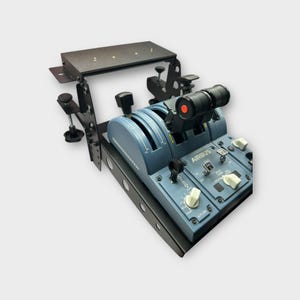 May include: A black metal stand with a flat top surface and adjustable legs. The stand is holding a blue Airbus throttle quadrant with multiple switches and knobs. The throttle quadrant has the text "AIRBUS" printed on it.