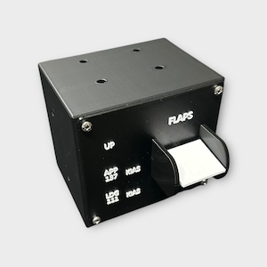 Puede incluir: Un dispositivo rectangular negro con la palabra "FLAPS" en letras blancas. El dispositivo tiene una solapa blanca y varias etiquetas blancas, incluyendo "UP", "APP 237 KIAS" y "LDG 111 KIAS". El dispositivo tiene cuatro pequeños agujeros en la parte superior.