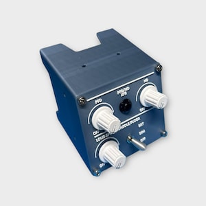 May include: A gray plastic box with three knobs and a switch. The knobs are labeled "PFD", "PFD/ND XFR", and "ND". The switch is labeled "LOUD SPEAKER CONSOLE/FLOOR".