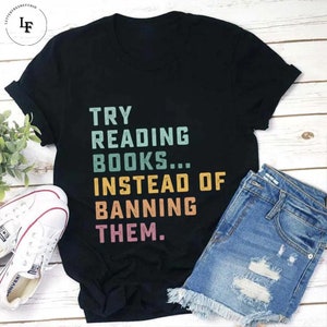 May include: Black t-shirt with a vintage-style graphic that reads "TRY READING BOOKS...INSTEAD OF BANNING THEM."