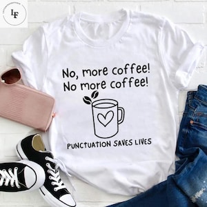 May include: White t-shirt with a black graphic of a coffee cup with a heart and the text "No, more coffee! No more coffee! Punctuation saves lives."