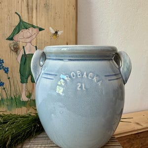 Könnte beinhalten: Eine hellblaue Keramik-Kanne mit zwei Henkeln und dem Text "ROBACKA 2L" an der Seite.