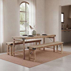 Può includere: Un tavolo da pranzo in legno chiaro con due panche abbinate. Il tavolo e le panche sono appoggiati su un tappeto tessuto. Il tavolo è apparecchiato con piatti, bicchieri e un vaso con rami decorativi. La stanza ha una finestra con tende trasparenti.