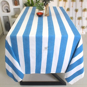 May include: A white and blue striped tablecloth with a blue stripe width of approximately 3 inches. The tablecloth is made of cotton and has a simple, classic design.