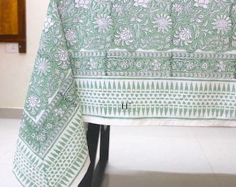 May include: A green and white tablecloth with a floral pattern. The tablecloth has a border with a geometric design. The tablecloth is made of cotton and is perfect for a dining table.