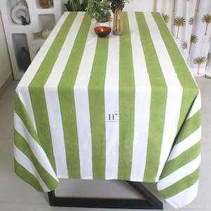 May include: Green and white striped tablecloth with a logo that says "The Heart of Home".