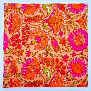 May include: A pink and orange floral print fabric with a white border. The fabric features a repeating pattern of flowers and leaves.