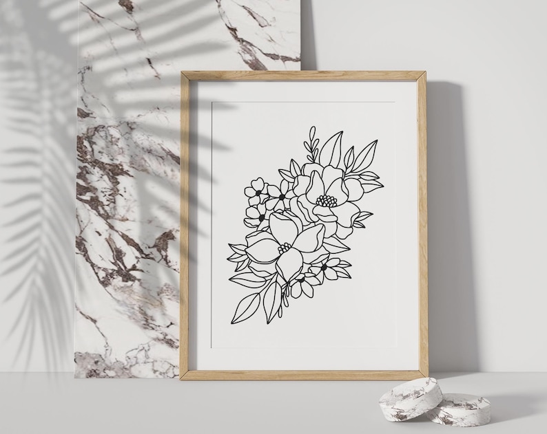 May include: A black and white line drawing of a floral bouquet with various flowers and leaves. The drawing is framed in a light wood frame and is displayed against a white background.
