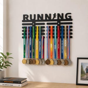 May include: A black wall-mounted medal display rack featuring the word RUNNING with a runner silhouette integrated into the letter N. The rack has multiple horizontal bars for hanging various colorful race medals on ribbons.
