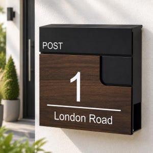May include: A rectangular wall-mounted post box featuring a matte black metal top section with the word POST in white text. The lower portion has a dark wood grain finish displaying the number 1 and the text London Road in white lettering.
