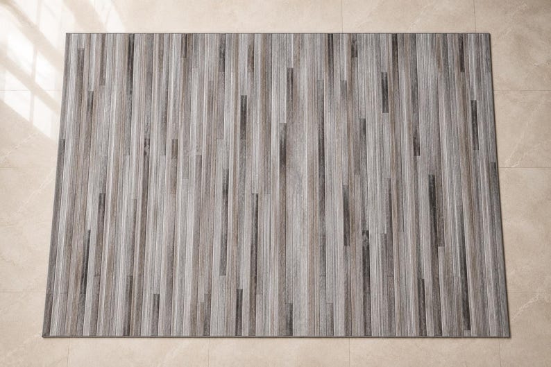 May include: A rectangular area rug featuring a vertical striped pattern in shades of gray, charcoal, and white. The design consists of varying widths of linear bands that create a textured appearance across the entire surface of the floor covering.