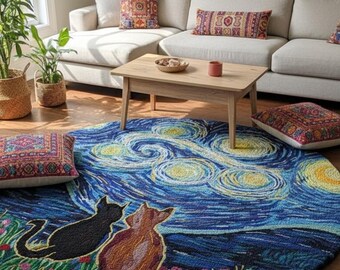 May include: A round rug featuring a starry night design with two cat silhouettes. The rug has a blue and yellow color scheme, with a green border of flowers. The rug is placed in a living room with a beige sofa and decorative pillows.