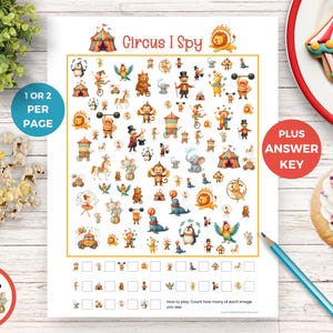 May include: A printable "Circus I Spy" game sheet with colorful illustrations of circus animals and performers. The sheet includes the text "Circus I Spy", "1 or 2 per page", and "Plus Answer Key". A pencil, popcorn, and a cupcake are also visible.