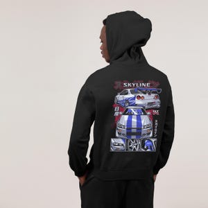 May include: Black hoodie with a white and blue illustration of a Nissan Skyline GT-R on the back. The illustration includes Japanese text that says "Skyline" and "GT-R".