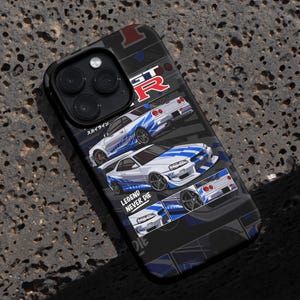 Pu&ograve; includere: Una custodia per iPhone nera con una grafica bianca e blu di una Nissan Skyline GT-R. La custodia presenta il testo "LEGEND NEVER DIE" e "GT-R" in bianco.