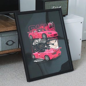 May include: Framed art print featuring a pink sports car design. The artwork includes the text "S2000 VeilSide" and other Japanese text. The image is set against a dark background and framed in black.