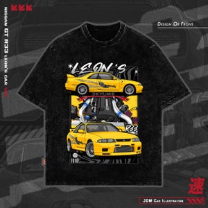 May include: Black t-shirt featuring a yellow Nissan GT R33 car illustration. The design includes the text "LEON'S" and "SKYLINE", along with "R33" and "JDM Car Illustration". The shirt has a crew neck and short sleeves.