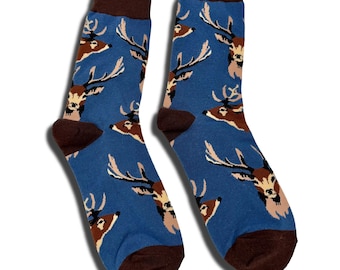 May include: A pair of crew socks featuring a repeating pattern of brown and white deer heads on a blue background. The socks have solid dark brown cuffs, heels, and toes. The deer heads are depicted in profile and facing forward, showcasing antlers.